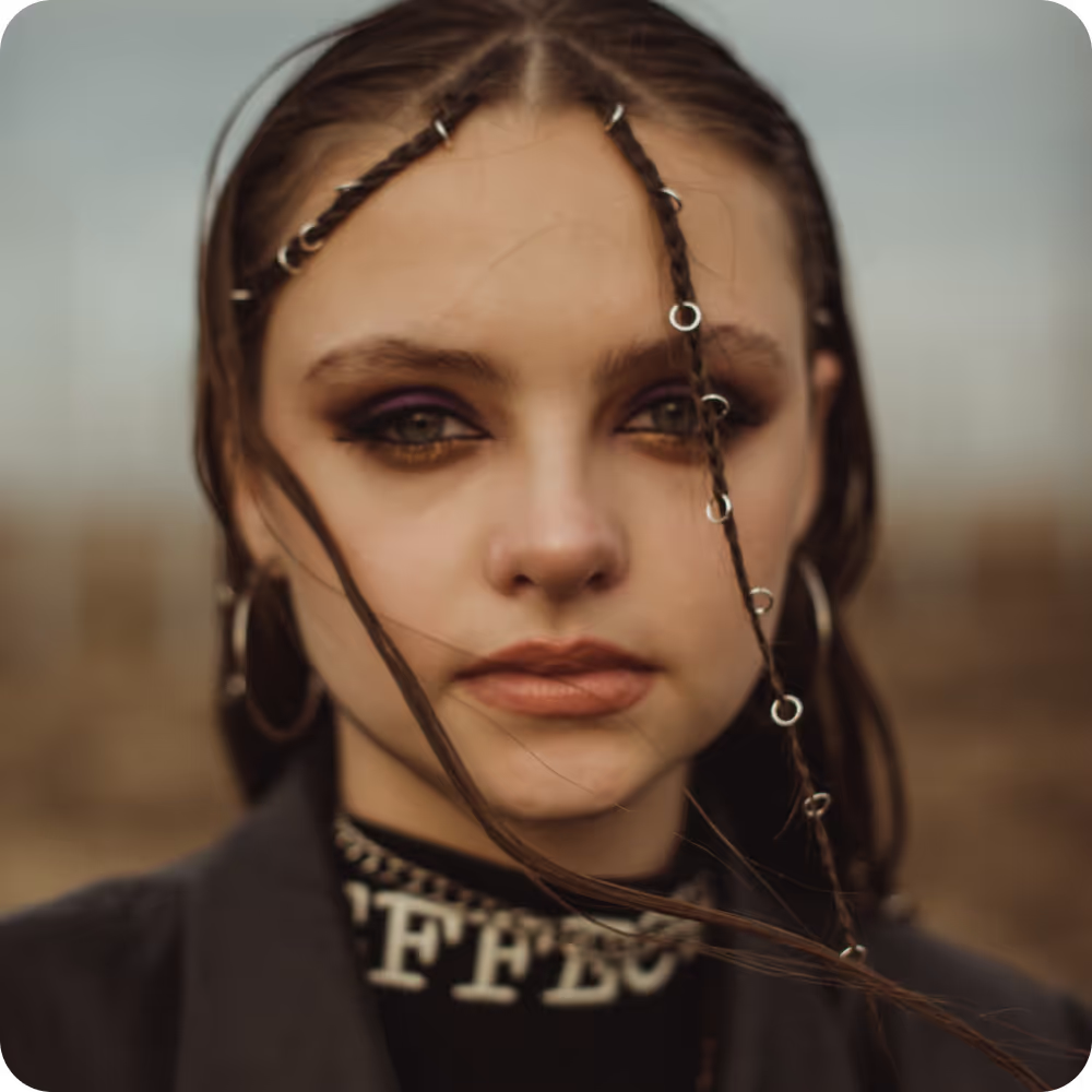 Image of a woman with braided hair adorned with various piercings, showcasing a unique and stylish appearance.